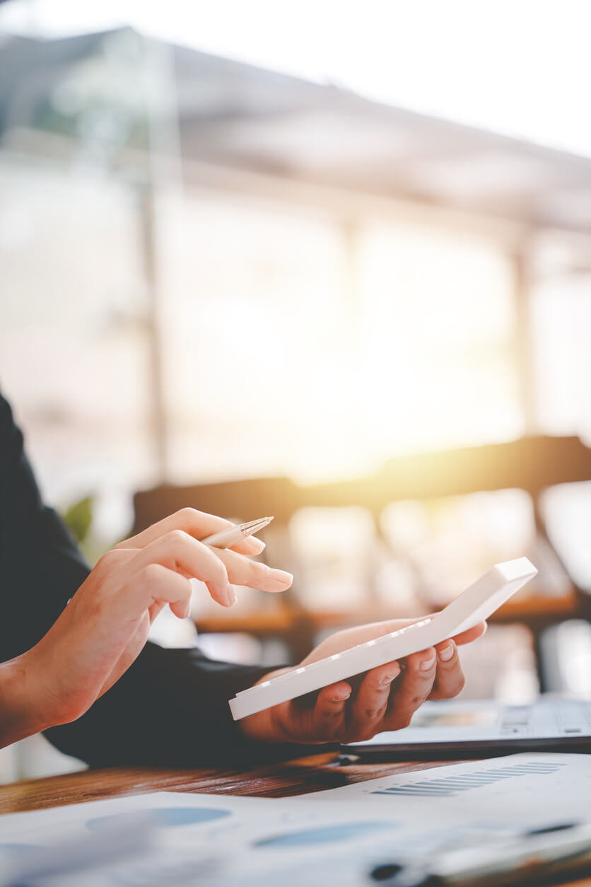 business woman or accountant who are using a calculator to calculate business data Accounting documents and laptop computer at the office business idea